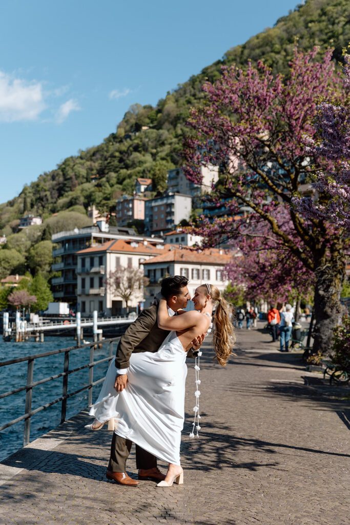 man holds bride's leg to kiss on Lake Como 