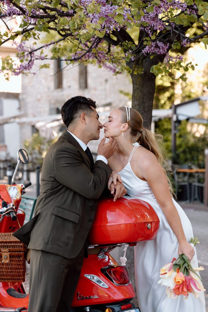 bride and groom kiss under spring blooms in Italy 