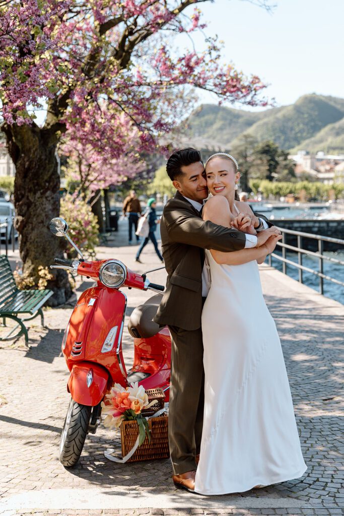 groom hugs bride from behind at lake como elopement 
