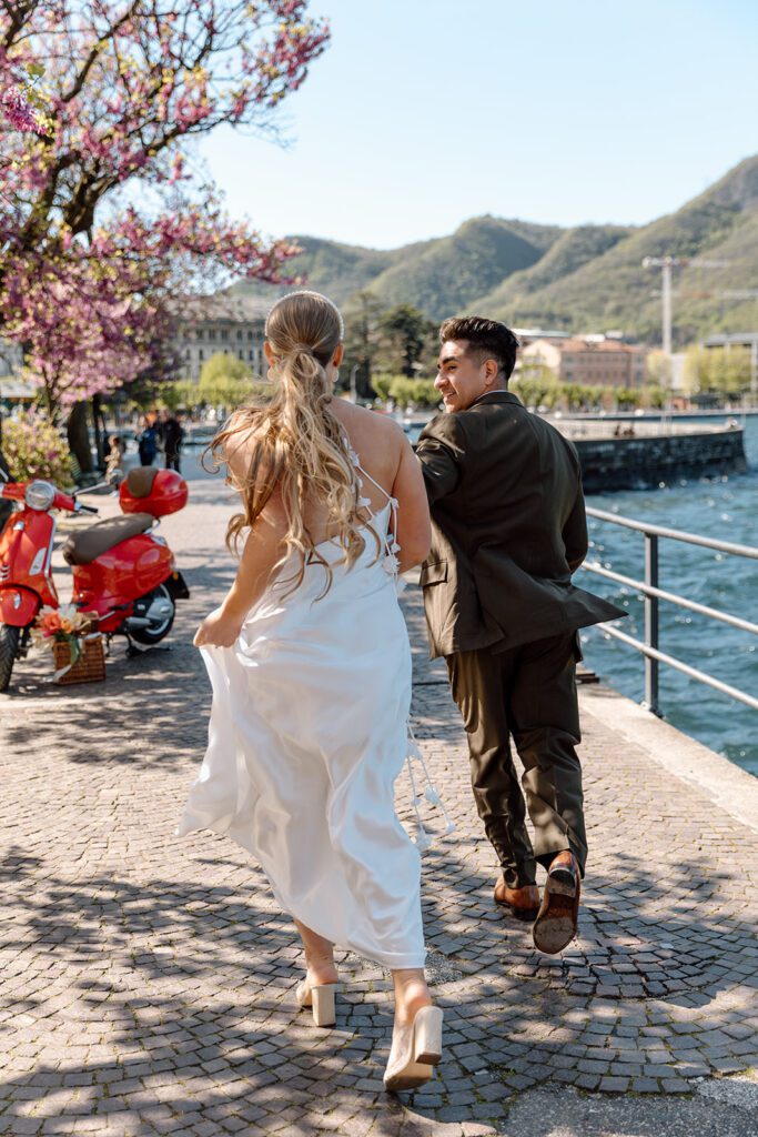 bride and groom run in italy to red vespa 