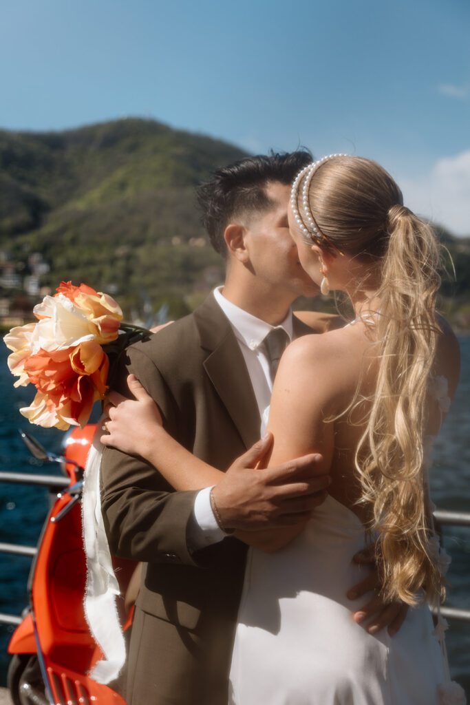 bride and groom kiss with tulip bouquet and ponytail 