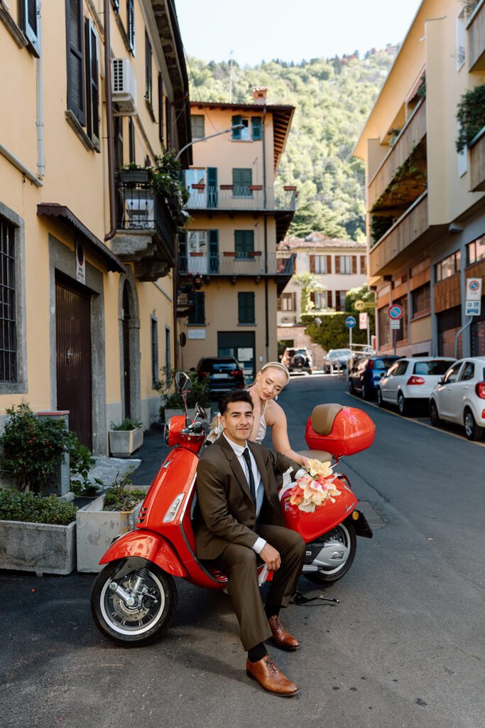 bride looks at groom on red vespa on italian street 
