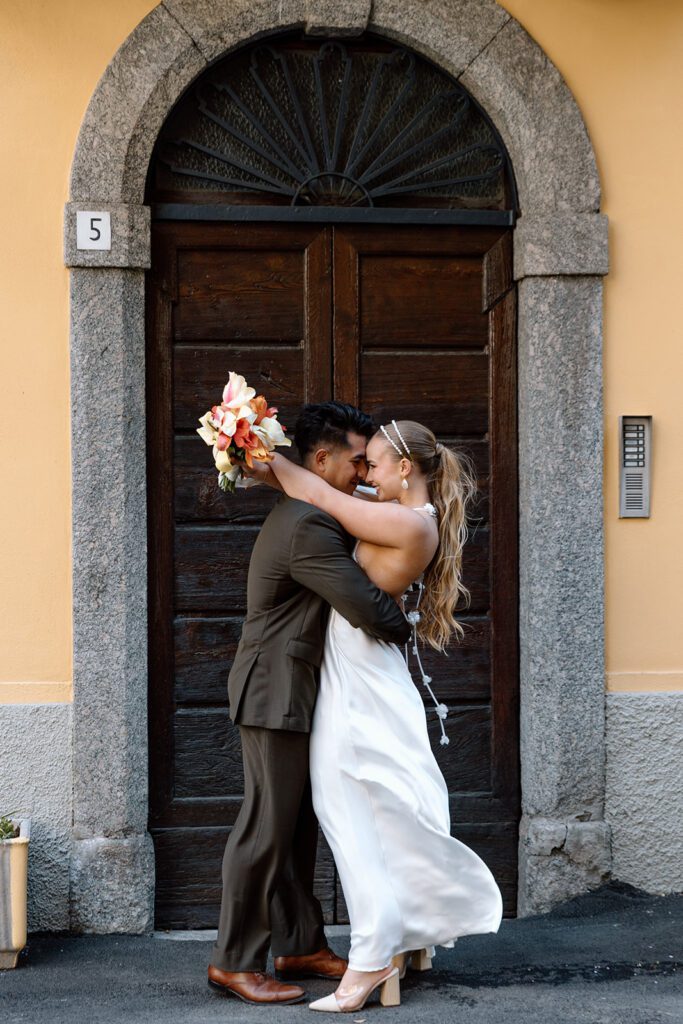 bride and groom embrace by arched italian door in Lake Como 