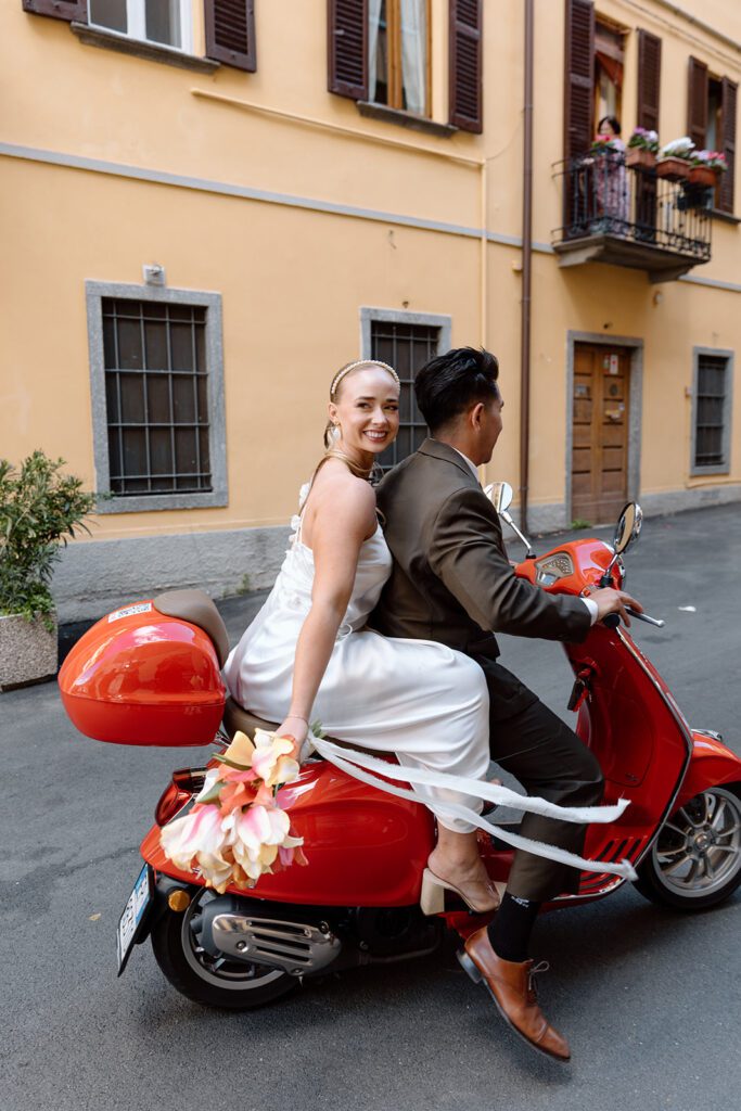 bride looks back and smiles on vespa at Italian elopement shoot 