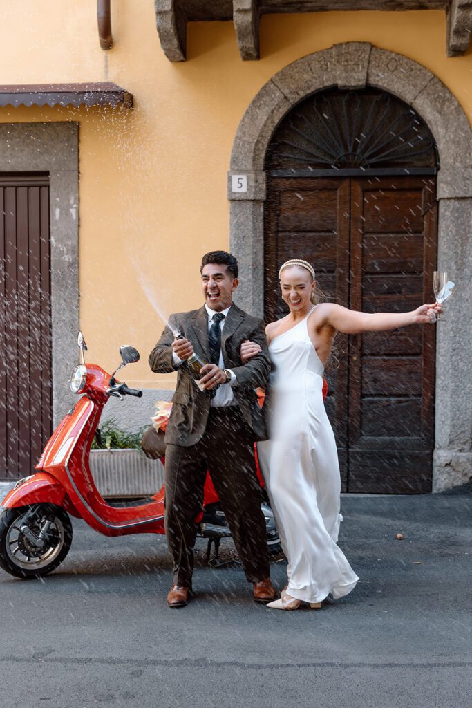 couple open bubbly in elopement shoot in Italy 