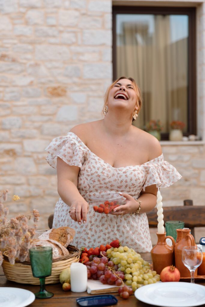 bride laughs as women sets table for sunset patio dinner