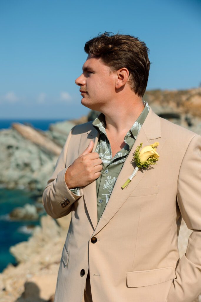 groom looks over the sea waiting for his bride to join him 