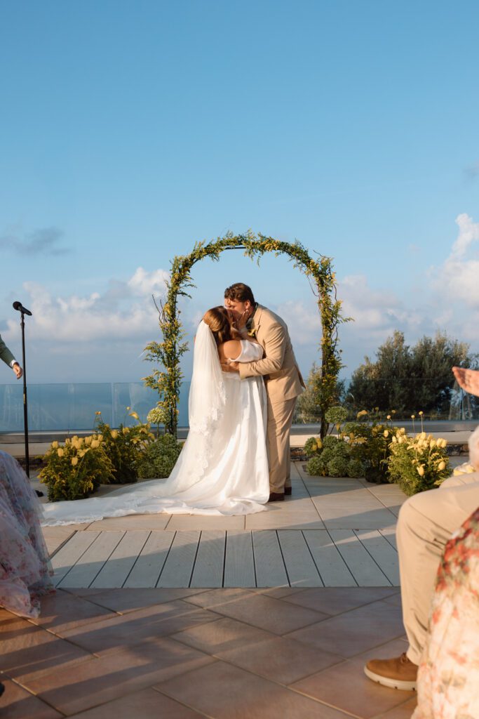plus size bride tipped by groom in first kiss at dream greek elopement 