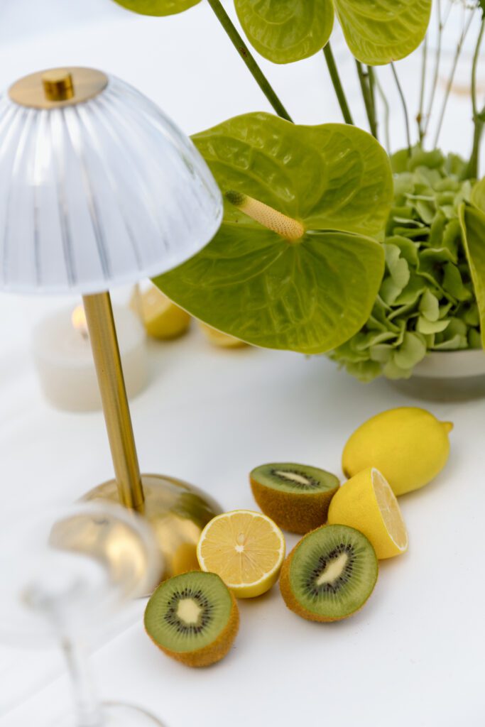 table setting with gold lamp, kiwis, lemons and green hydrangeas 