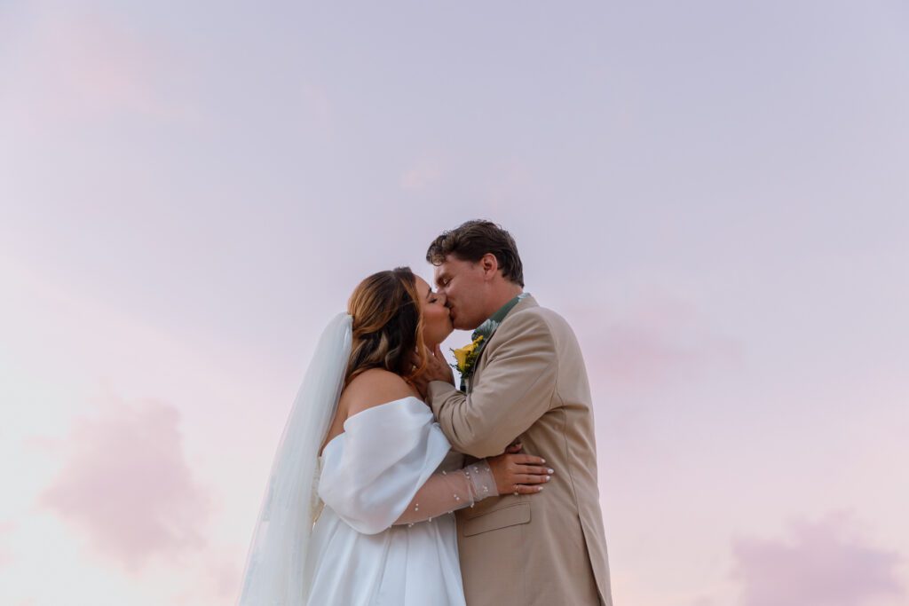 bride and groom kiss at twilight