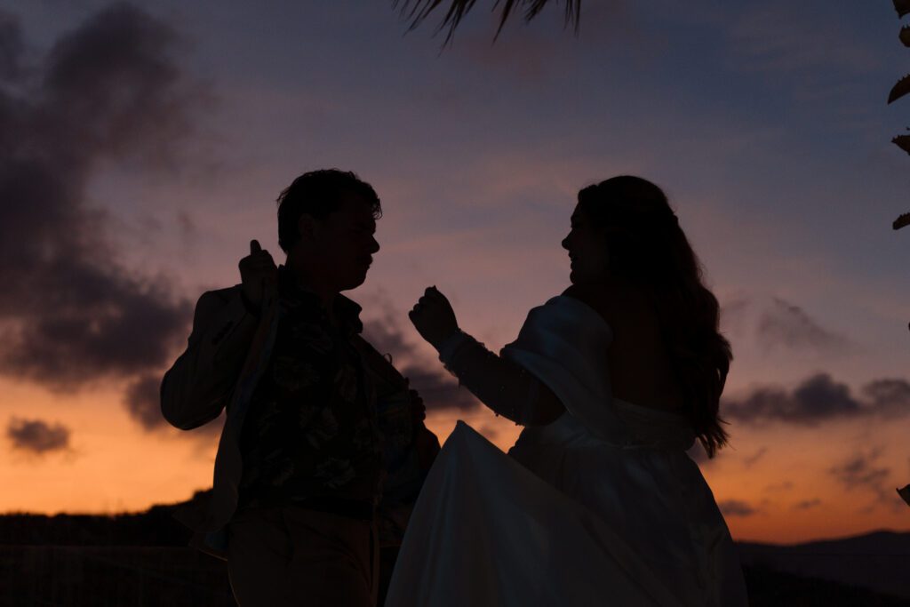 silhouette of bride and groom dancing at sunset at their dream greek elopement